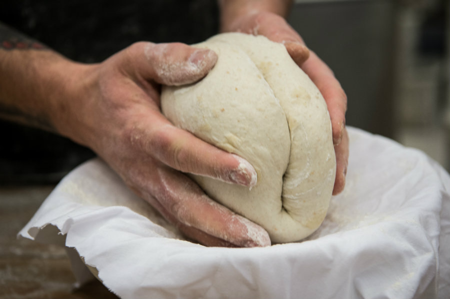 Mani che impastano il pane. Foto di Francesco Vignali
